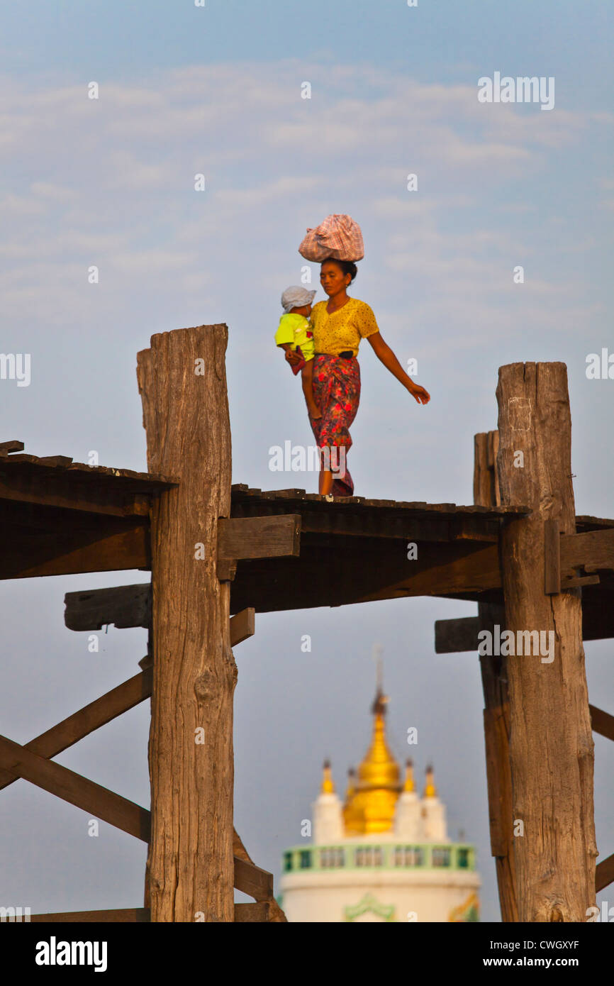 Il birmano utilizzare il teak U BEINS ponte per commutare tra il Lago Taungthaman presso sunrise - AMARAPURA, MYANMAR Foto Stock
