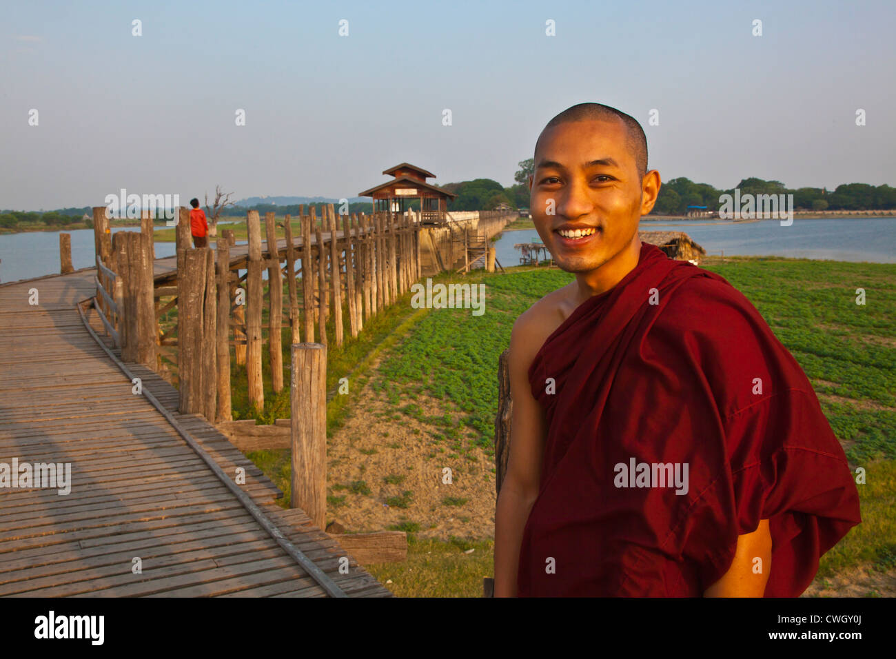 I MONACI BIRMANI utilizza il teak U BEINS ponte per commutare tra il Lago Taungthaman presso sunrise - AMARAPURA, MYANMAR Foto Stock