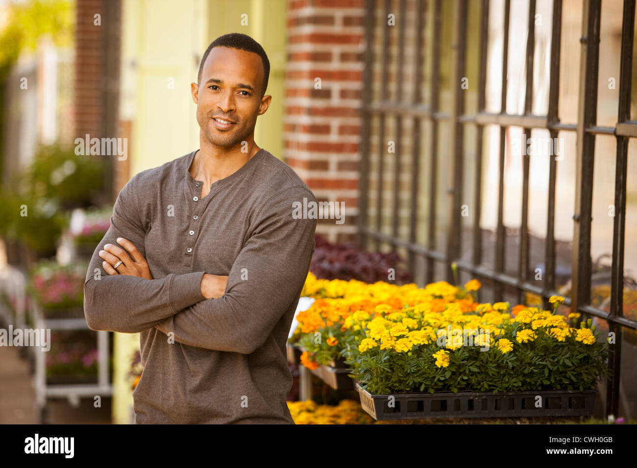 African American uomo in piedi vicino al negozio di fiori Foto Stock