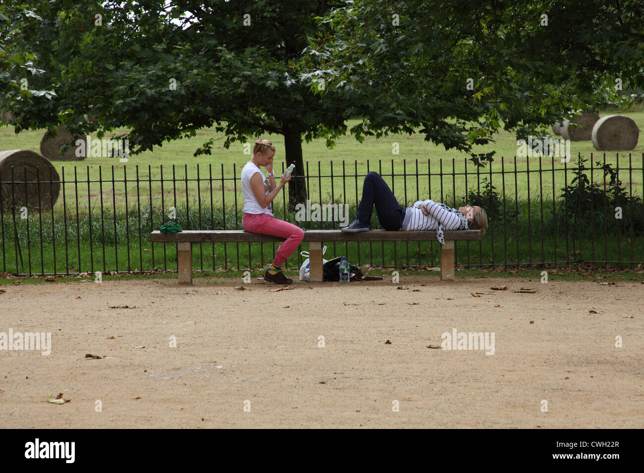 Amici sdraiati su una panchina nel parco. Foto Stock