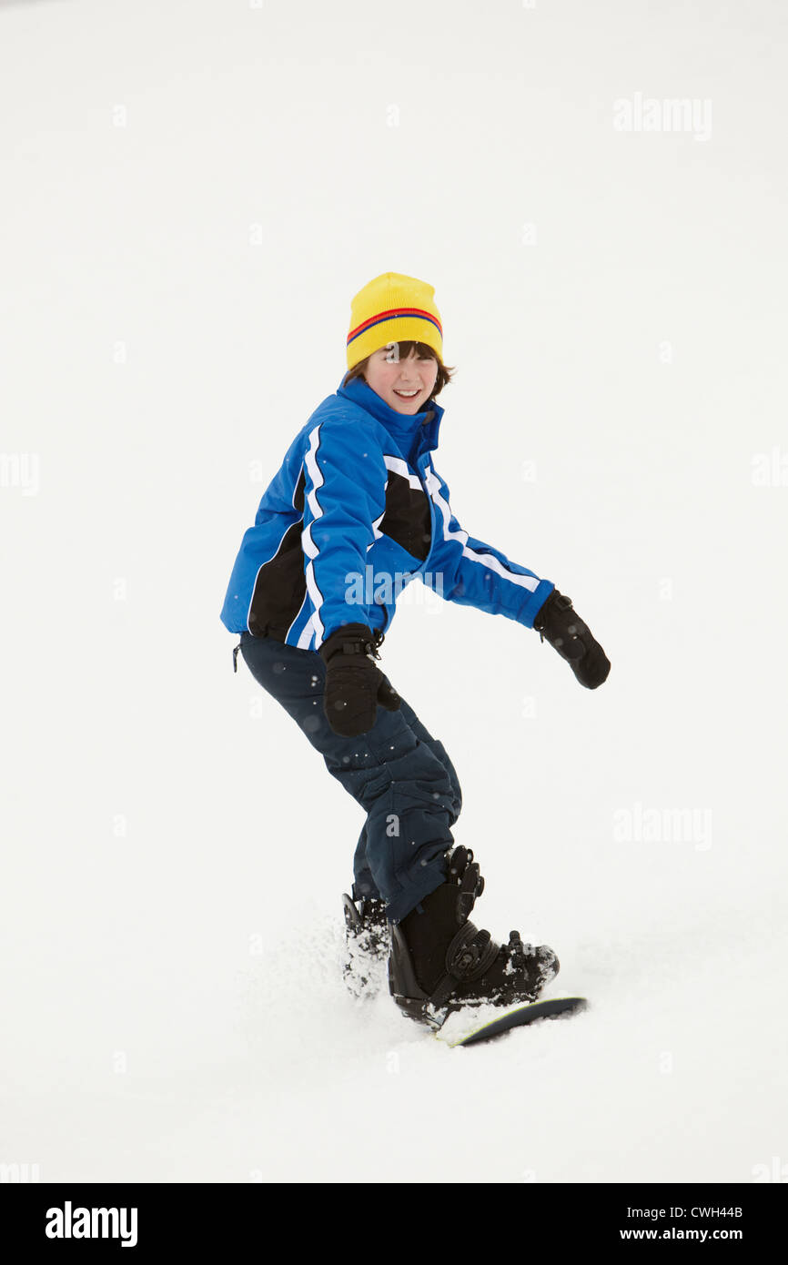 Ragazzo giovane lo snowboard in discesa in vacanza in montagna Foto Stock