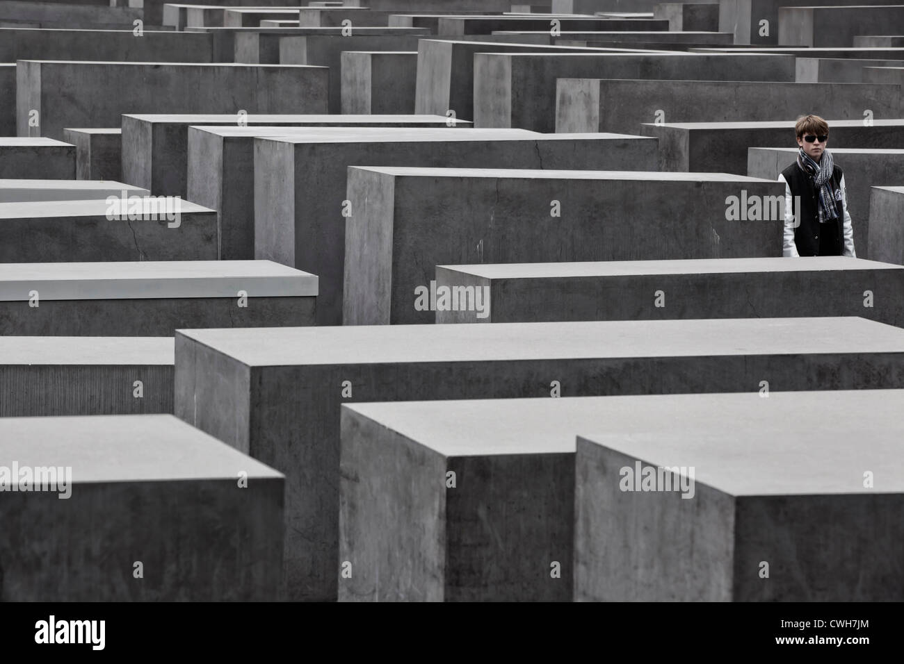 Una persona che cammina in olocausto memorial, Denkmal für die ermordeten Juden Europas, Holocaust Mahnmal visitatori Foto Stock