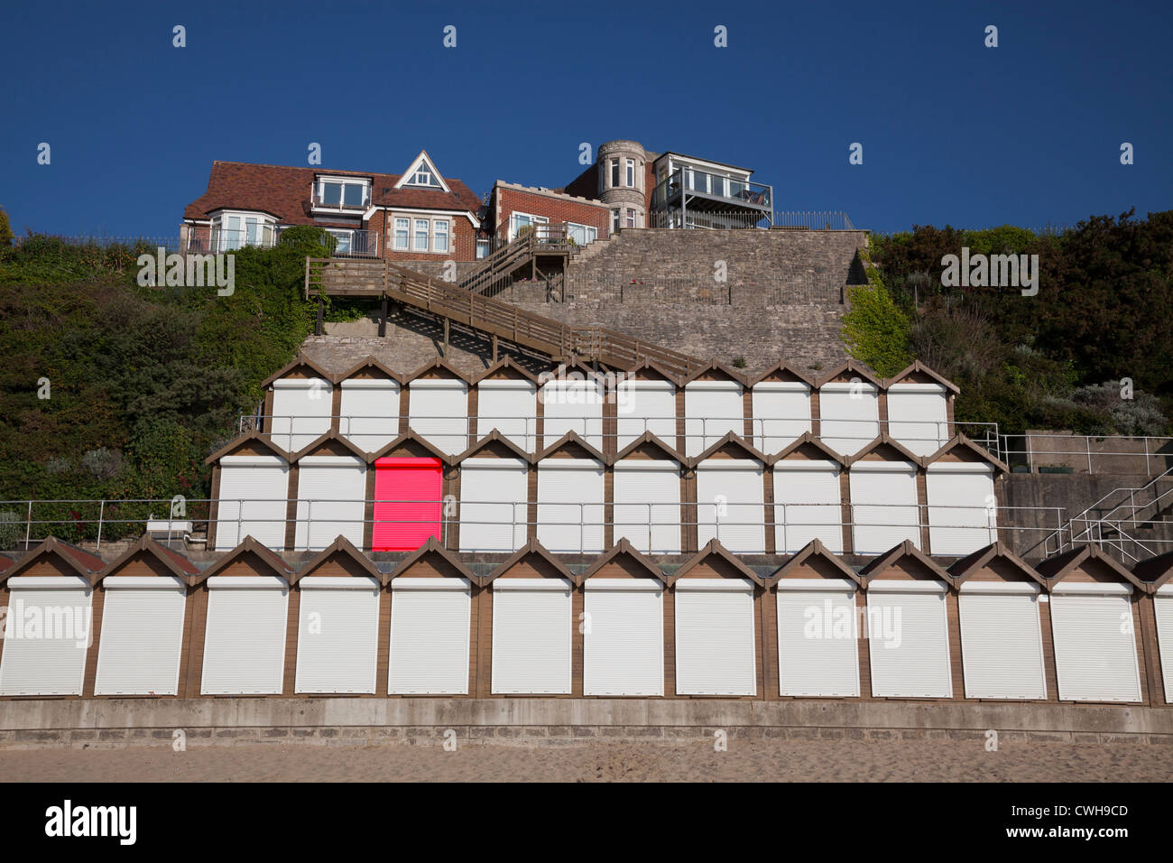 Tre livelli di cabine sulla spiaggia, con il rullo bianco otturatore porte e una porta rossa (creata digitalmente) Foto Stock
