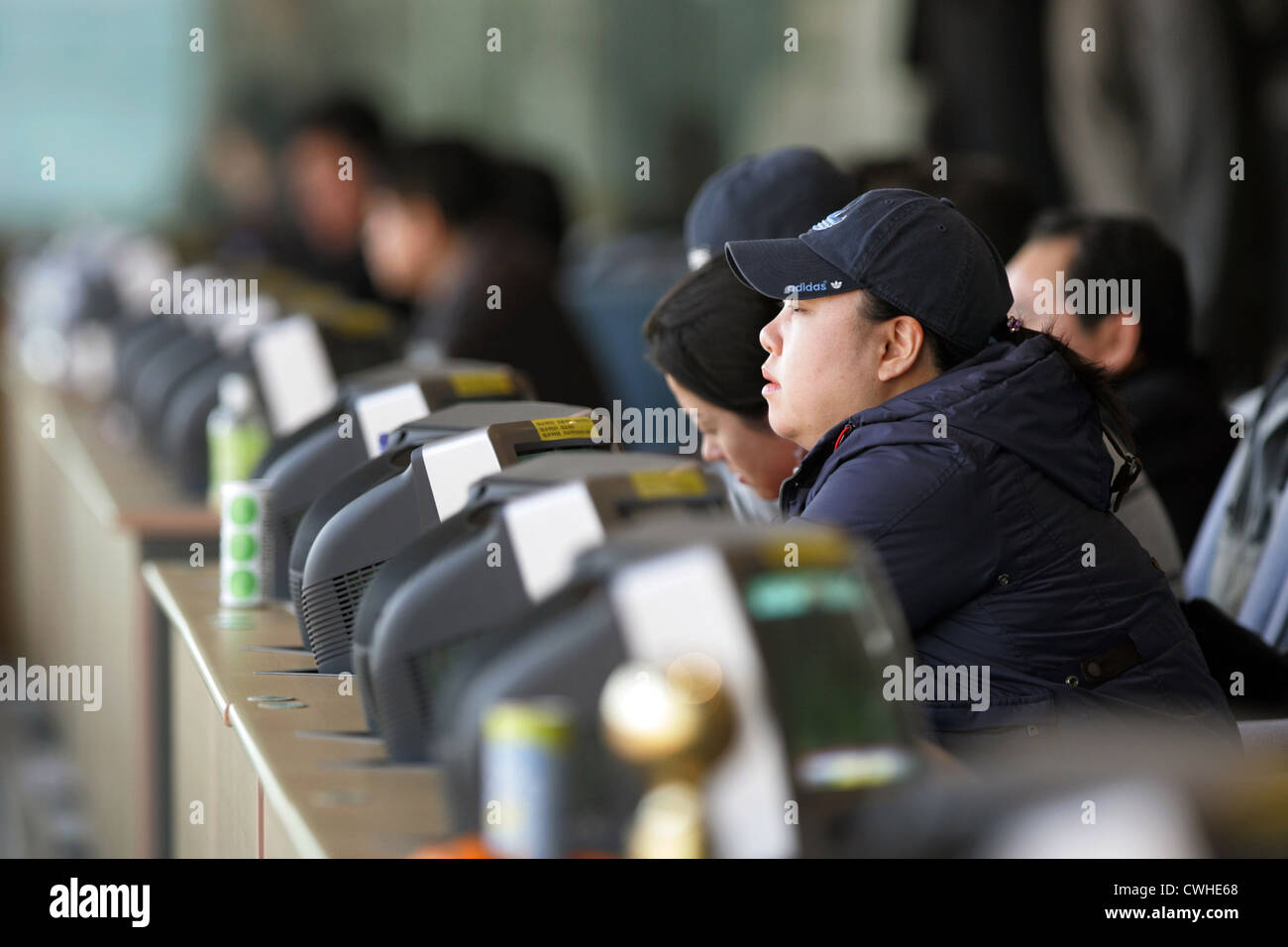 Seoul Racecourse visitatori sedersi nella parte anteriore del monitor nella sala di scommesse Foto Stock