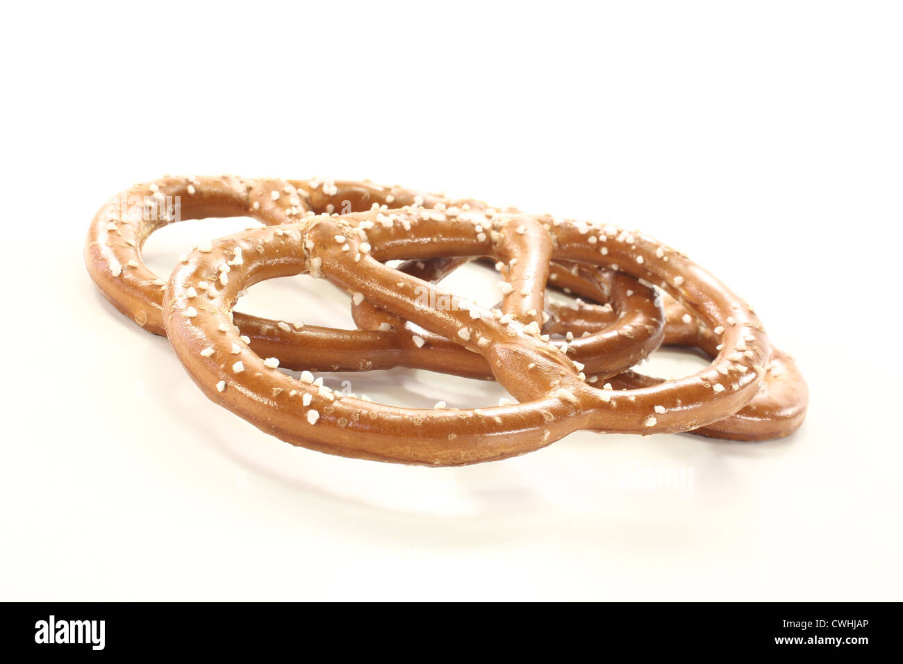 Tre pretzel bavarese con sale su uno sfondo luminoso Foto Stock