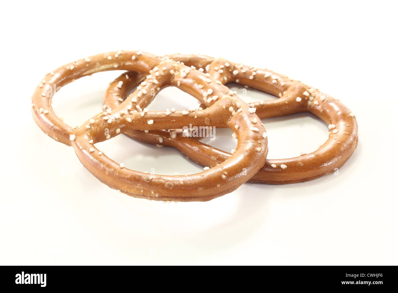 Due pretzel bavarese con sale su uno sfondo luminoso Foto Stock