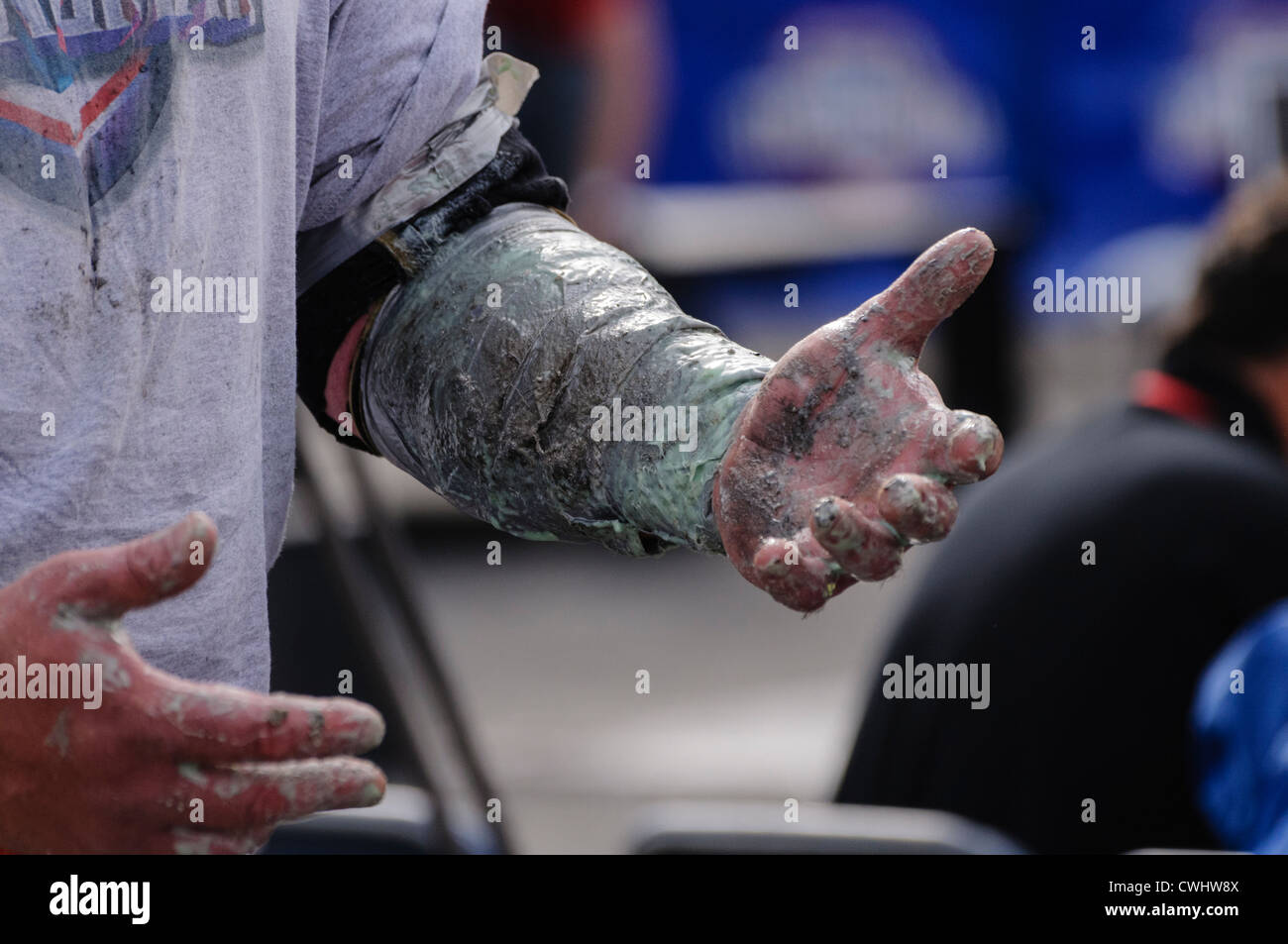 Uomo in competizione in uomo forzuto contest nastri il suo avambraccio per renderlo più facile da sollevare un molto pesanti Atlas Stone sul suo podio Foto Stock Uomo in competizione in uomo forzuto contest nastri il suo avambraccio per renderlo più facile da sollevare un molto pesanti Atlas Stone sul suo podio Foto Stock