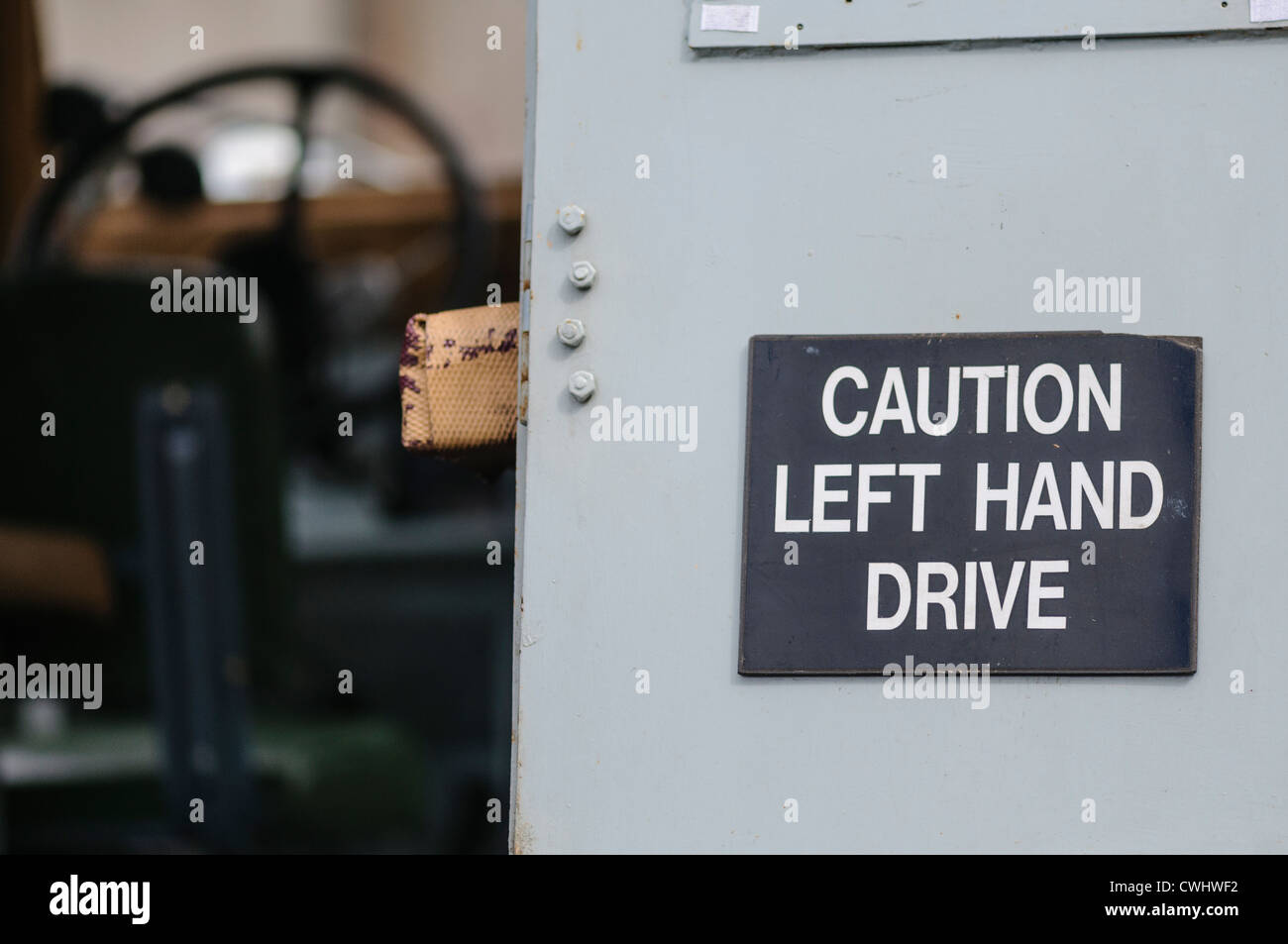 Segno sul retro di un vecchio Landrover seguente avvertimento agli automobilisti che si guida a sinistra. Foto Stock