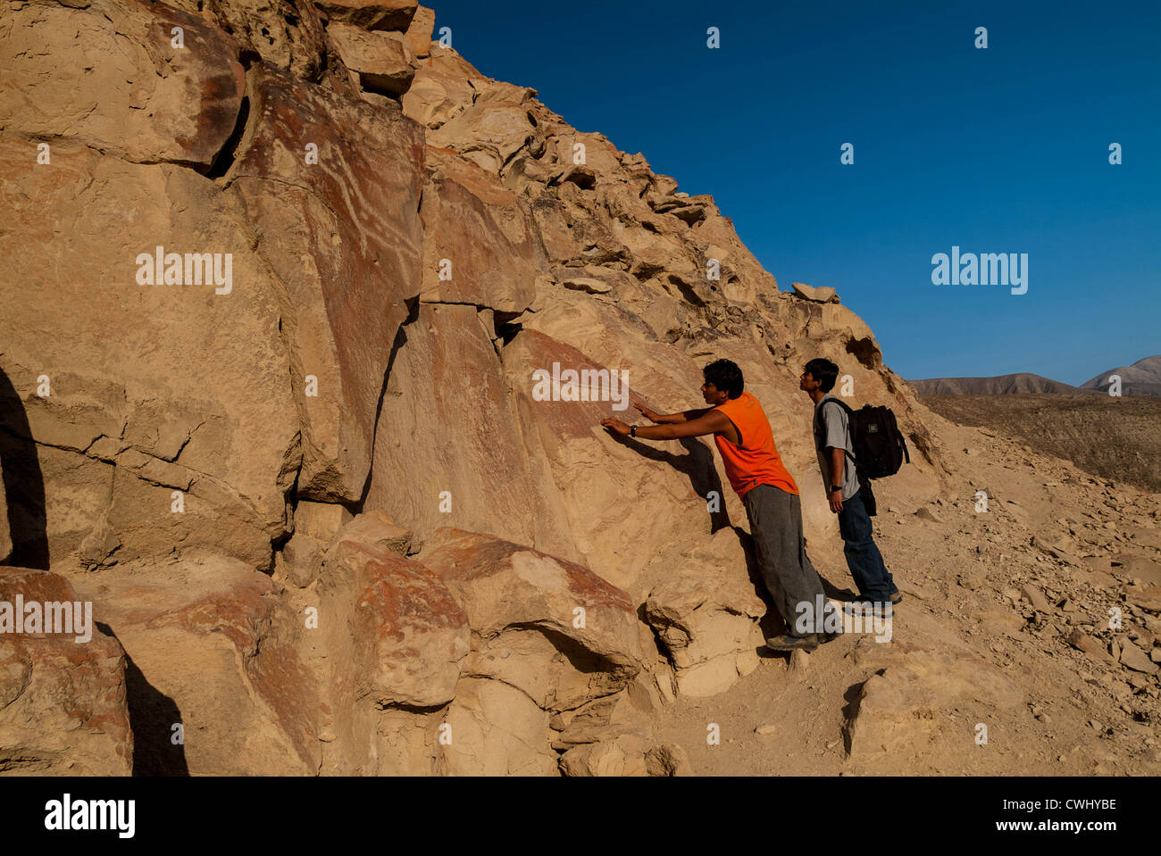 Guide peruviana sottolineando incisioni rupestri a Palpa Perù di petroglifi Chichictara America del Sud Foto Stock