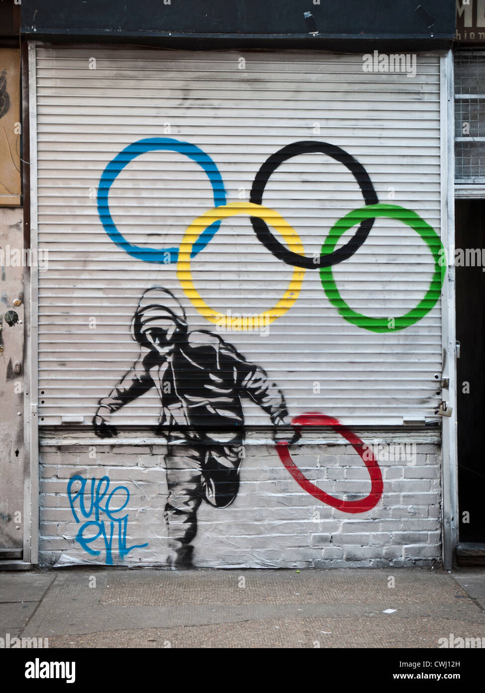 Street Art raffigurante una gioventù rubare uno degli anelli olimpici Foto Stock