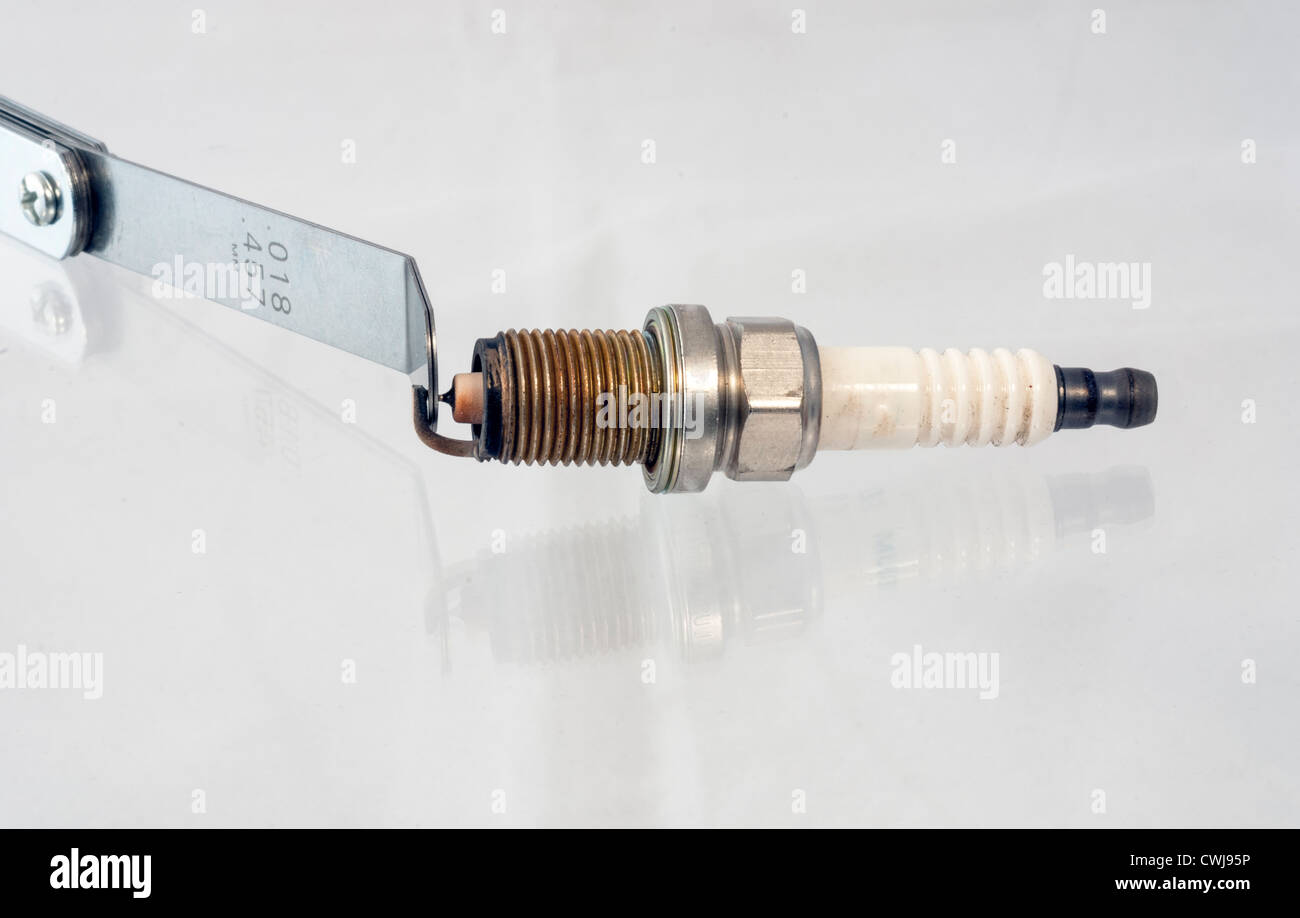 Utilizzando uno strumento di calibrazione di un divario di una candela di accensione Foto Stock