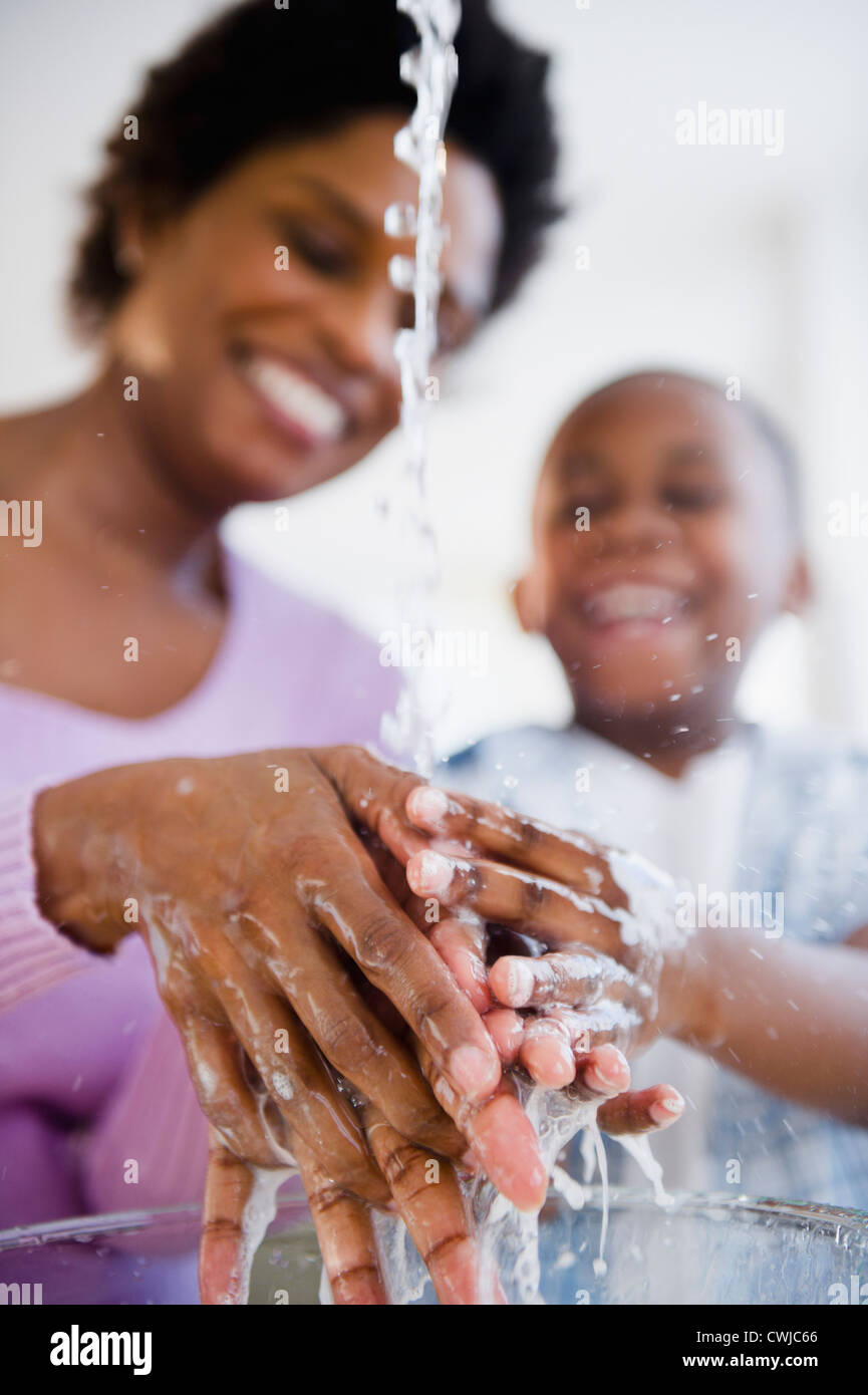 Madre nera e figlio di lavaggio delle mani Foto Stock