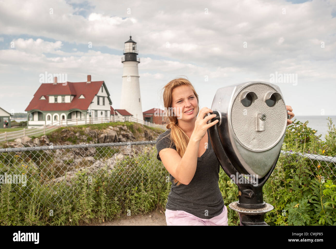 Giovane donna turistico con visualizzazione di telescopio, Portland Head Light, Cape Elizabeth Maine USA Foto Stock