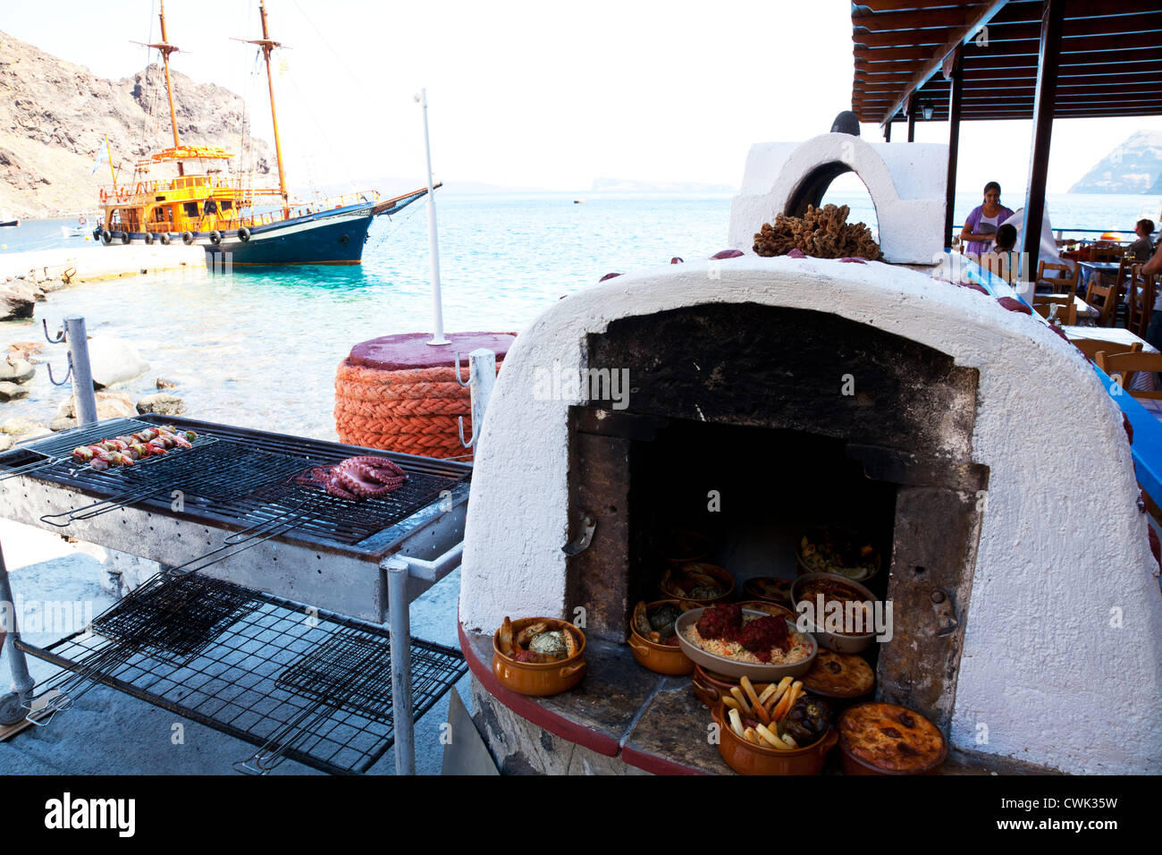 Polpo alla griglia e spiedini di gamberi sul barbecue a Santorini Grecia la cottura vicino al mare caldera cicladi Foto Stock