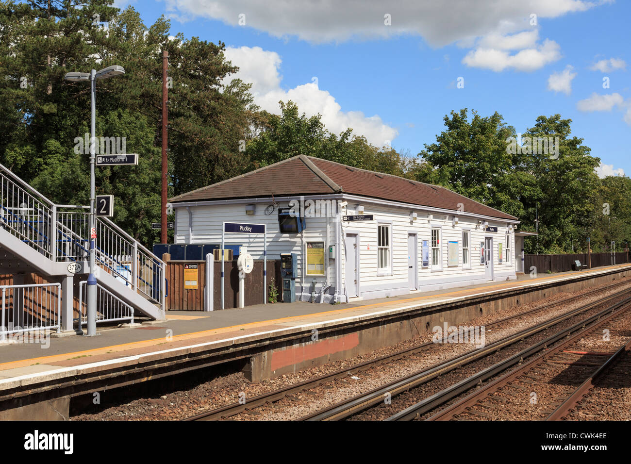 Guardando attraverso le linee ferroviarie per il vecchio edificio in legno rurale della stazione ferroviaria in Ashford a Londra la linea. Pluckley Kent England Regno Unito Foto Stock