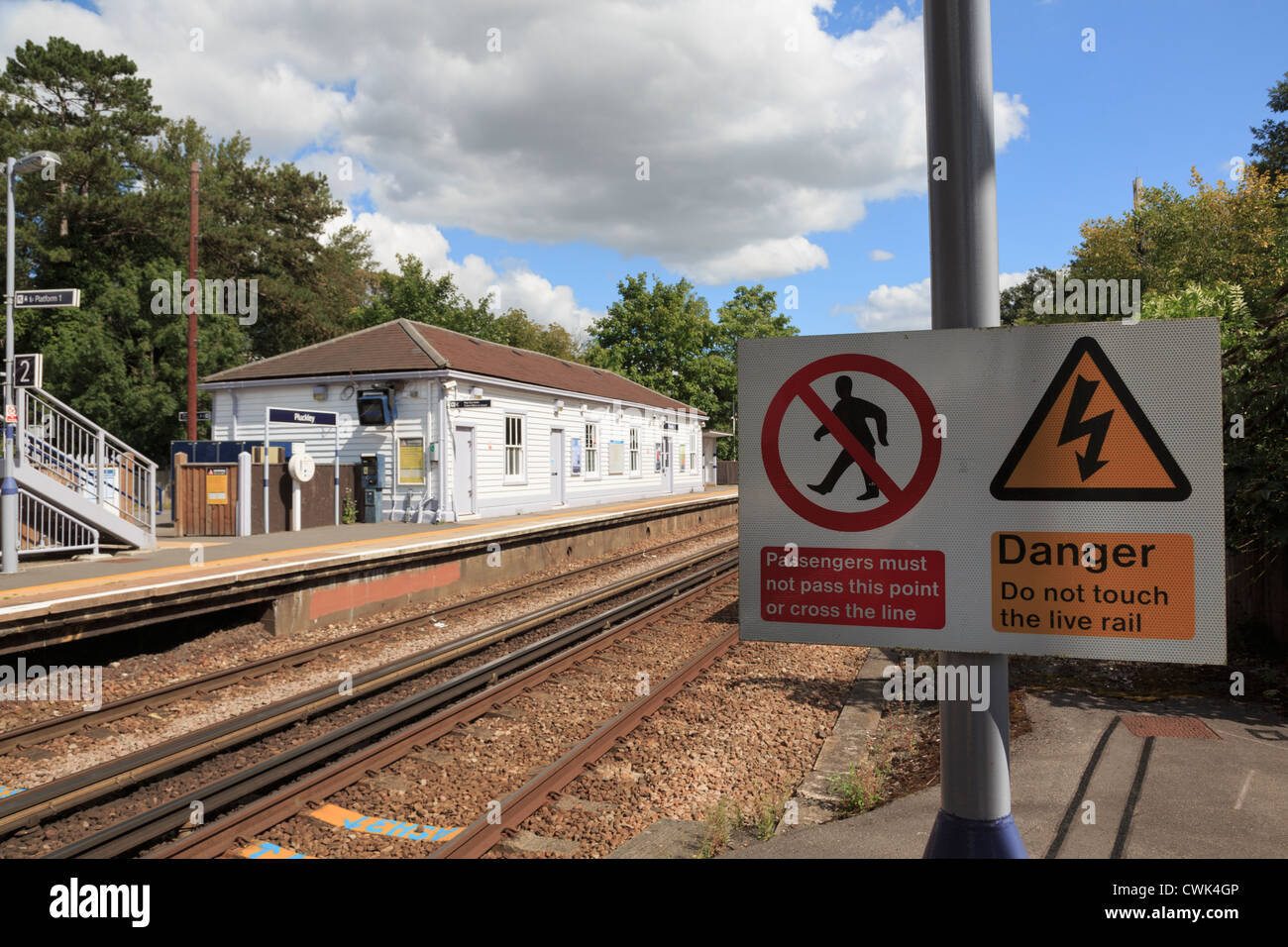 Elettrificata di binari ferroviari con segnaletica di pericolo attenzione ai passeggeri di non attraversare la via su Ashford alla linea di Londra Inghilterra Regno Unito Gran Bretagna Foto Stock