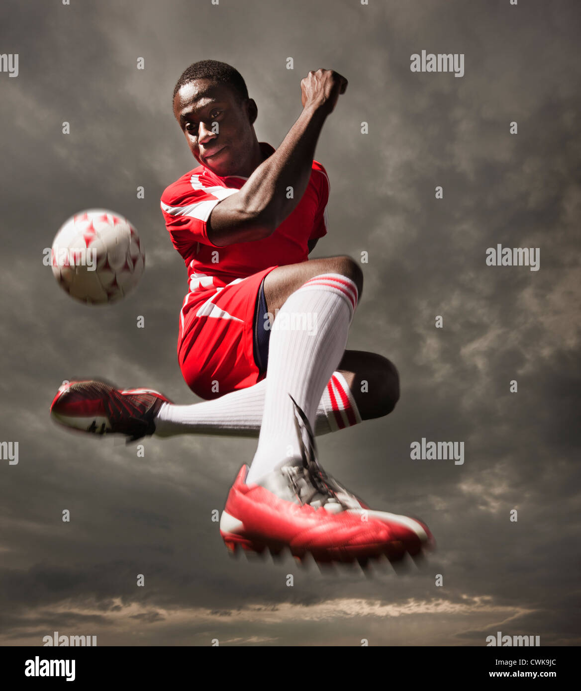 Nero giocatore di calcio calci palla Foto Stock