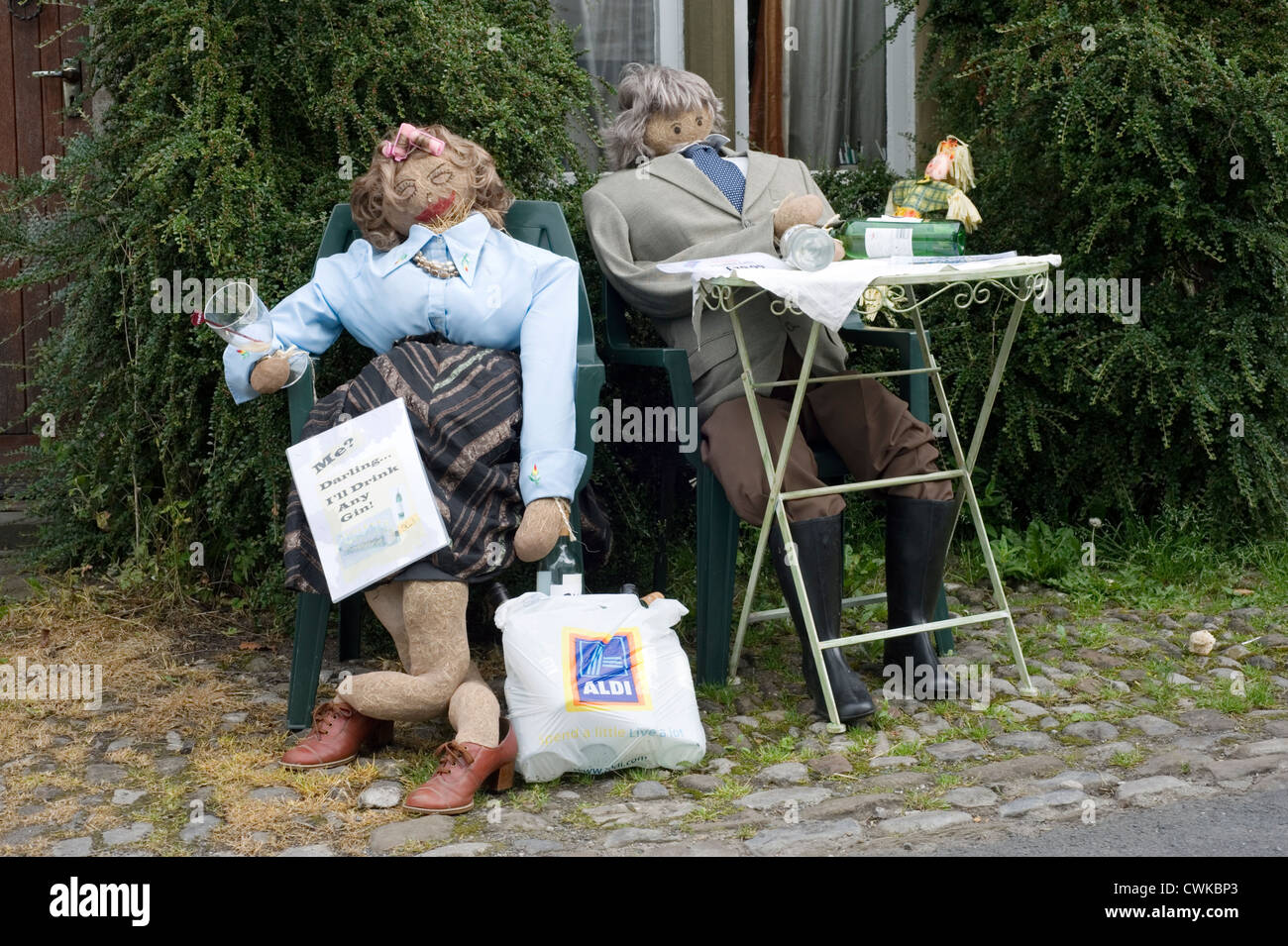 Scarecrows a kettlewell festival raffigurante un uomo e una donna con bevande a una tabella Foto Stock