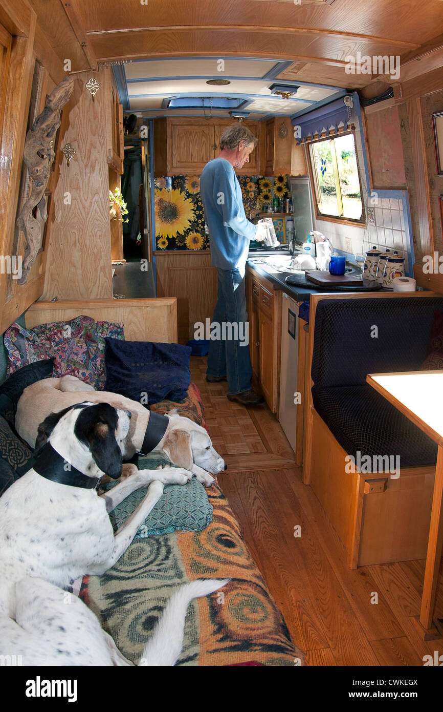 L'uomo che vive sul canal boat con due cani di salvataggio Foto Stock
