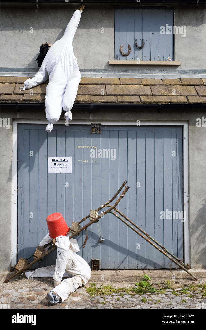 Scarecrows a kettlewell festival raffiguranti sventurati costruttori avente un incidente Foto Stock