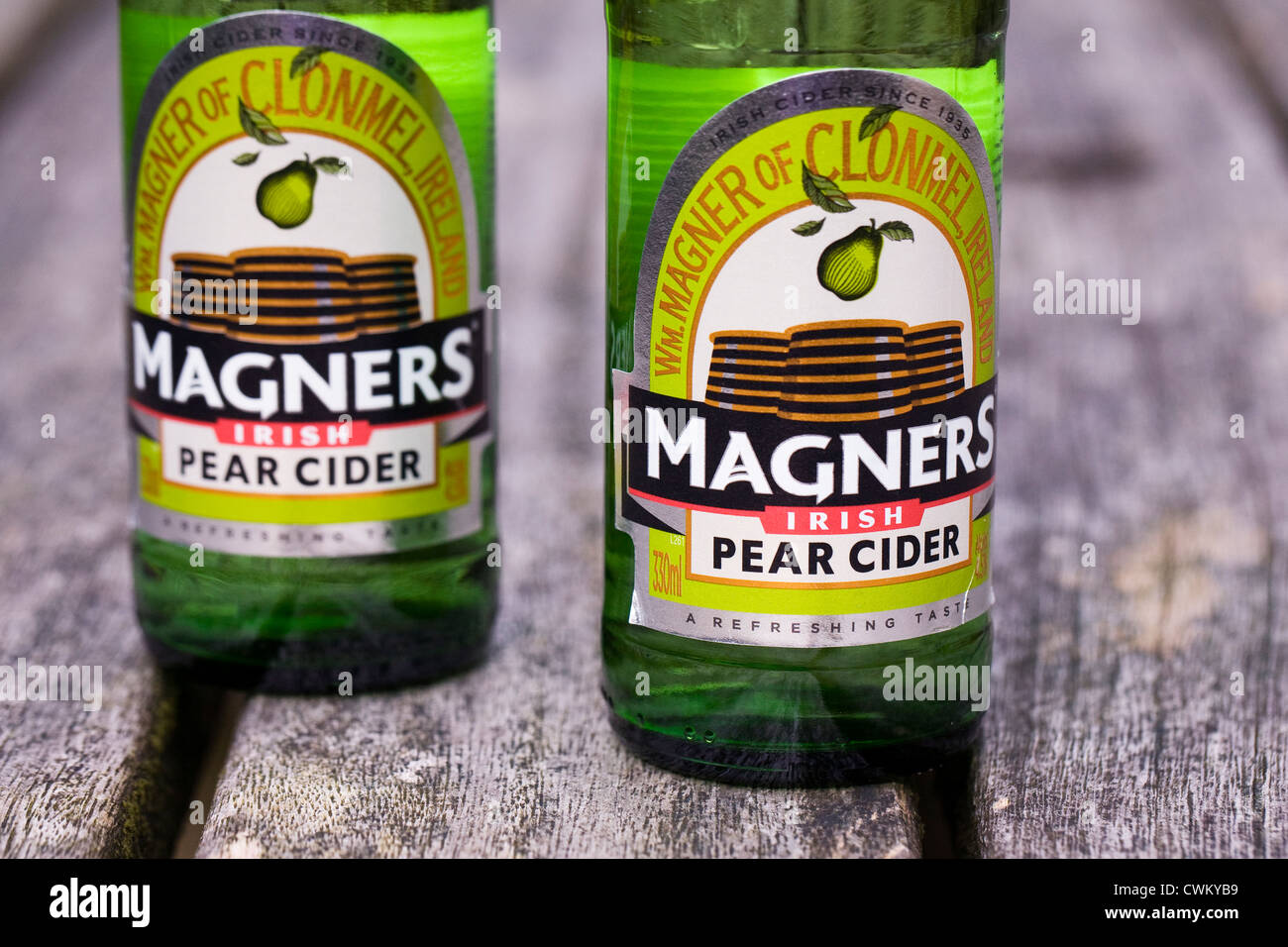 Bottiglie di Magners sidro di pere su di un tavolo di legno. Foto Stock