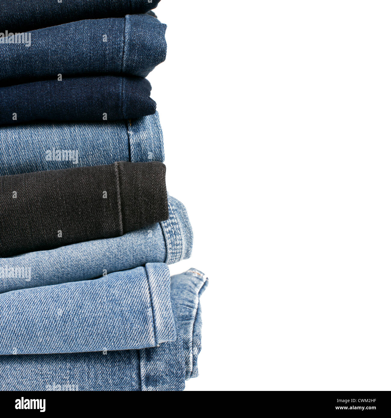 Pila di varie sfumature di piegato jeans blu su sfondo bianco Foto Stock