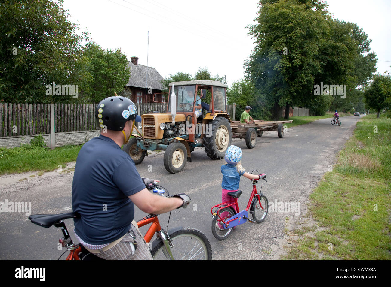 Ciclismo polacco papà e figlia di arresto per il trattore e il carrello per passare. Zawady Polonia centrale Foto Stock