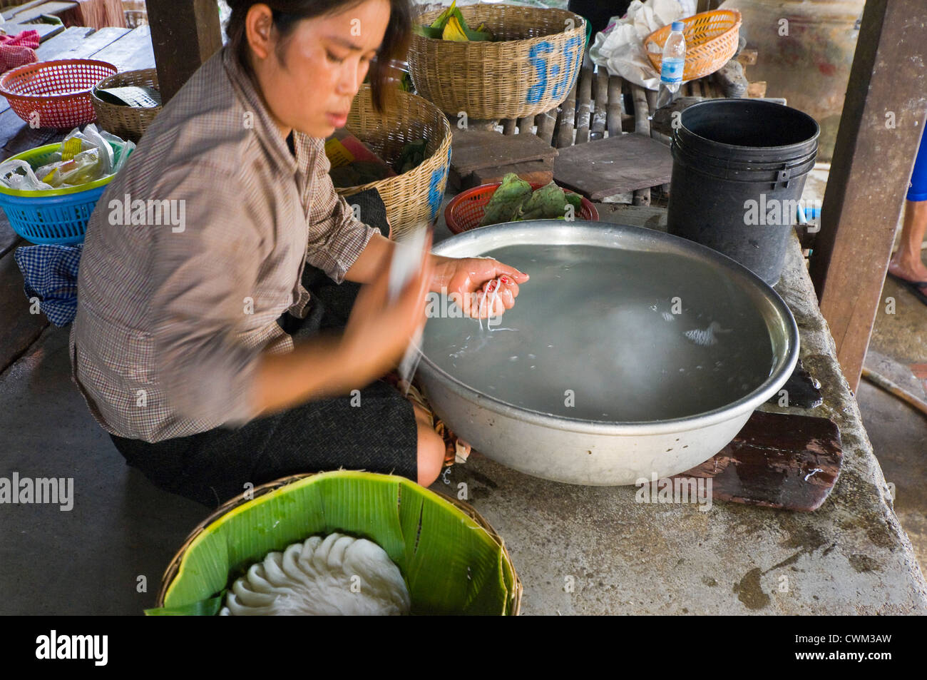 Chiudere orizzontale su ritratto di una donna cambogiana rendendo riso tagliatelle, kh'teaw, nei dintorni di base. Foto Stock