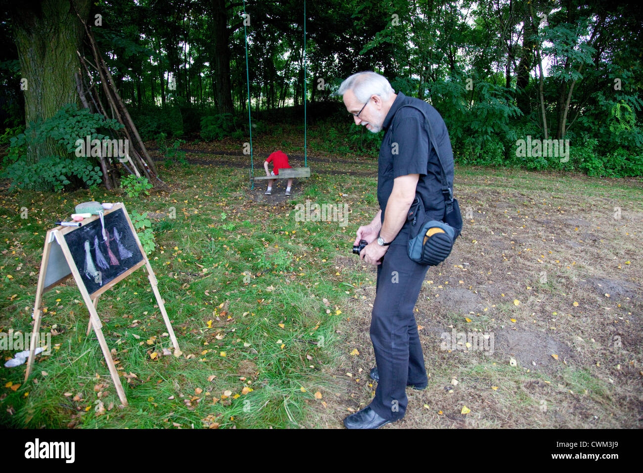 Fotografo età 65 catturare per bambini disegni di gesso sulla lavagna di donne danzanti. Zawady Polonia centrale Foto Stock