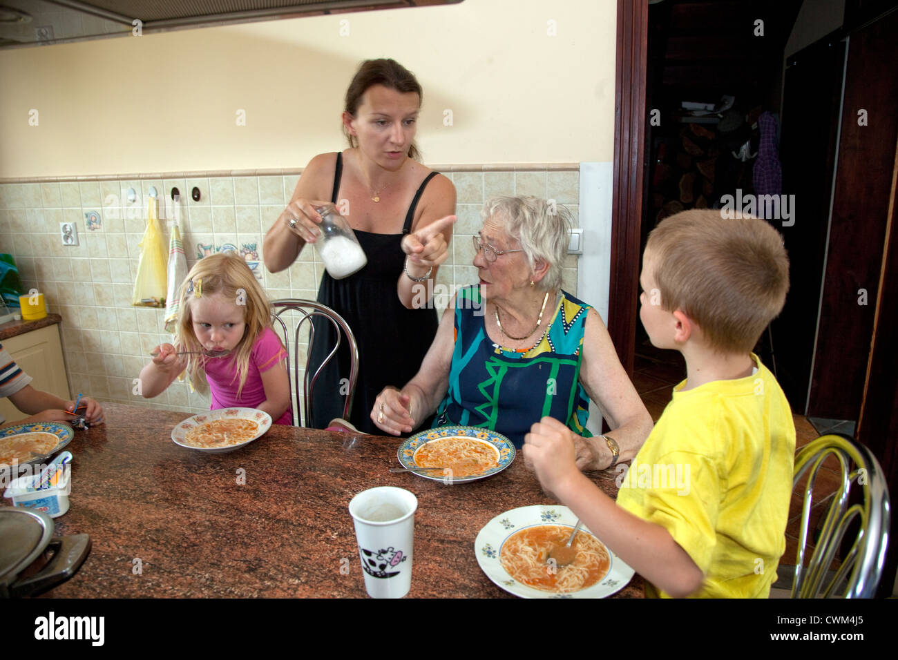 Madre polacco dirigere la zuppa di famiglia il pranzo con i bambini e la grande nonna età 8, 4, 32, 86 e 6. Zawady Polonia centrale Foto Stock