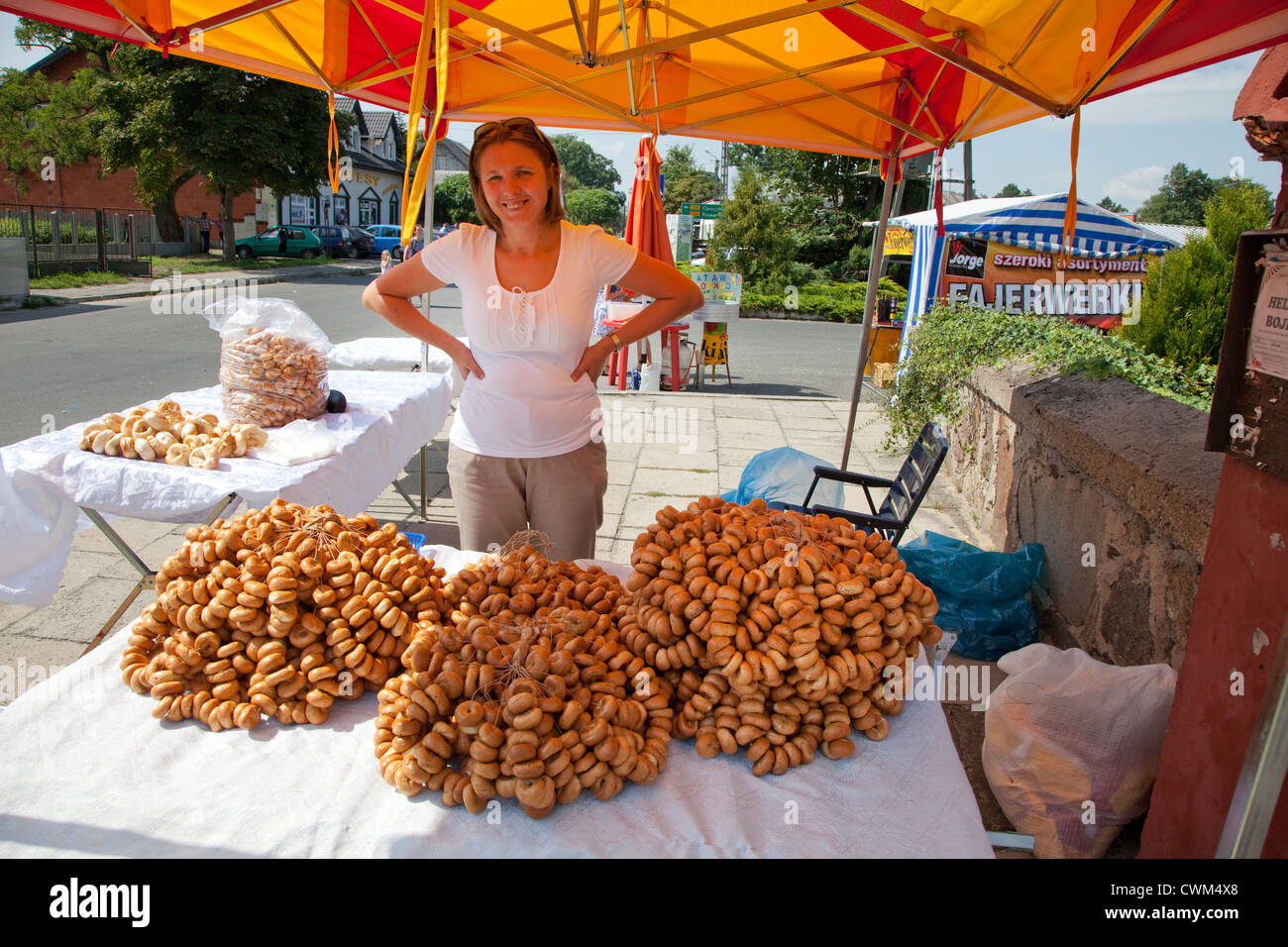 Chiosco di impegno donna vendita collane di pane (obwarzanek) alla domenica Rynek. Rzeczyca Polonia centrale Foto Stock