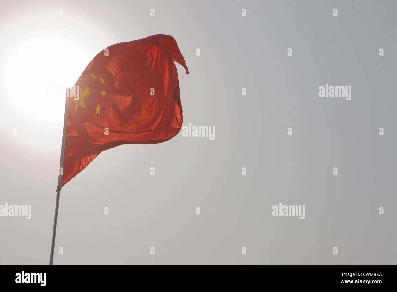 Cina, Pechino, bandiera cinese contro il sole Foto Stock