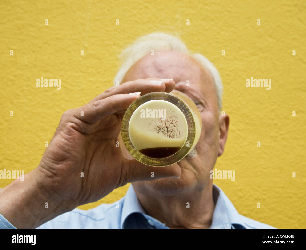 Un uomo di bere l'ultima feccia di una pinta di birra Guinness Foto Stock