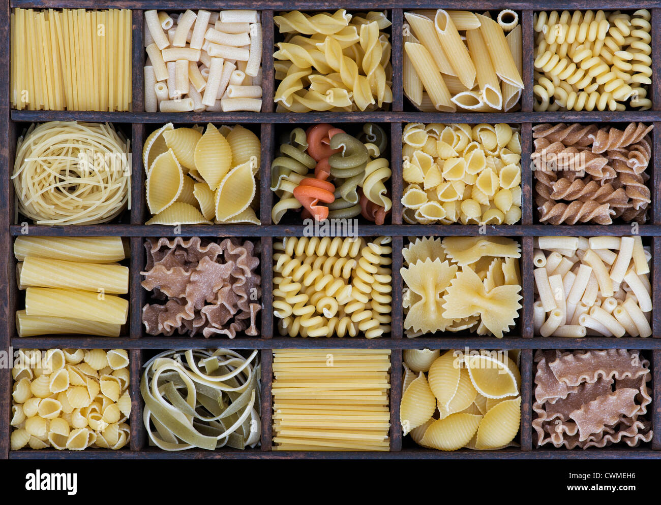 Diversi tipi di pasta essiccata in un vassoio di legno Foto Stock