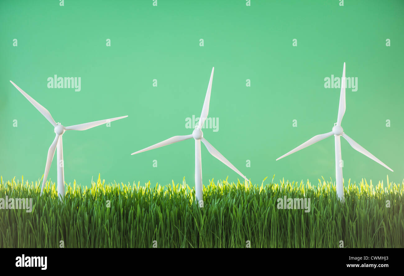Modello di turbine eoliche in erba su sfondo verde Foto Stock