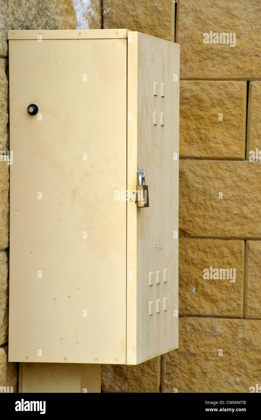 Bloccato power box giallo su un muro di mattoni Foto Stock