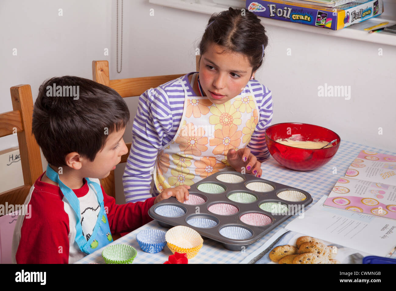 I bambini applicare la miscela di teglia Foto Stock