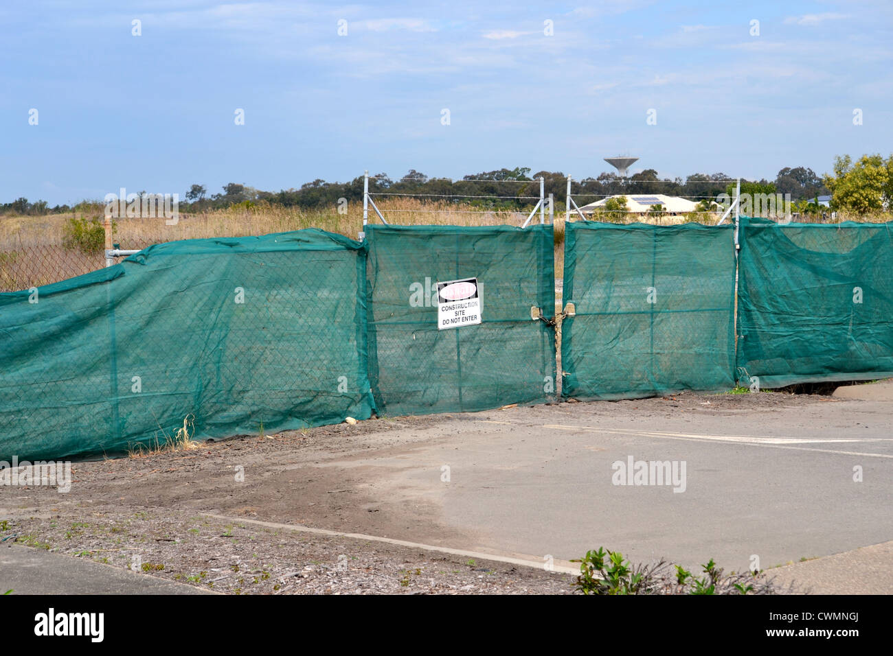 Sito in costruzione recintata con recinzione in acciaio avvolto in maglia verde Foto Stock