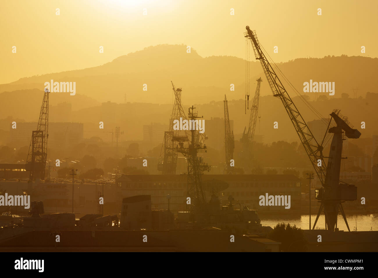 Gru industriali nel porto di Tolone al tramonto, Francia Foto Stock