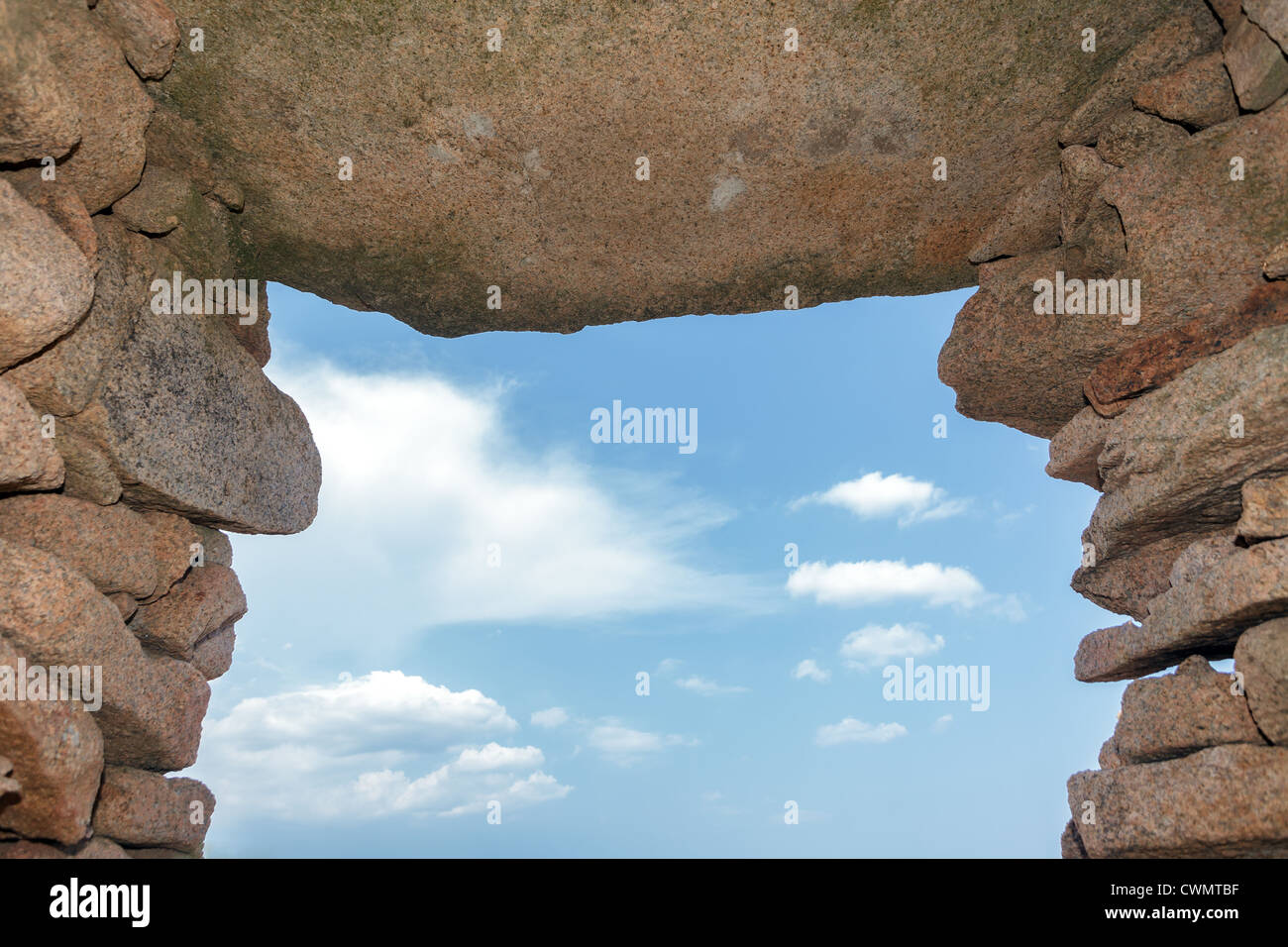 Il neolitico arcata in pietra sotto il blu cielo molto nuvoloso Foto Stock