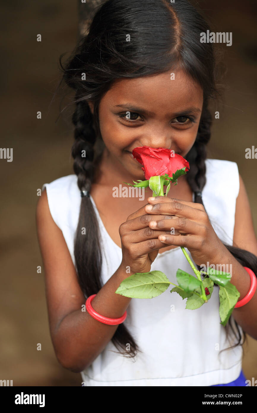Giovani indiani ragazza rurali tenendo una rosa di Andhra Pradesh in India del Sud Foto Stock