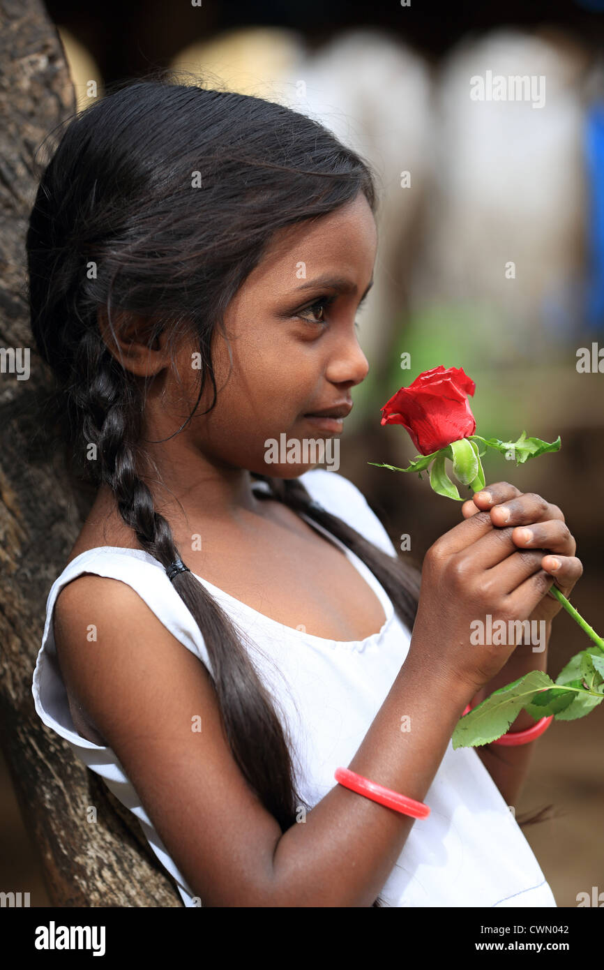 Giovani indiani ragazza rurali tenendo una rosa di Andhra Pradesh in India del Sud Foto Stock