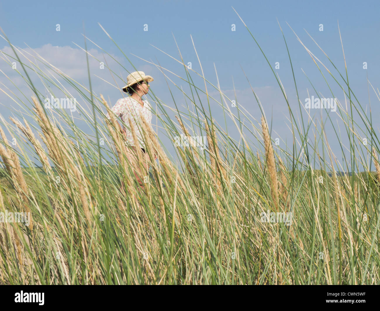 Donna in piedi in mezzo Marram erba in dune di sabbia. Foto Stock