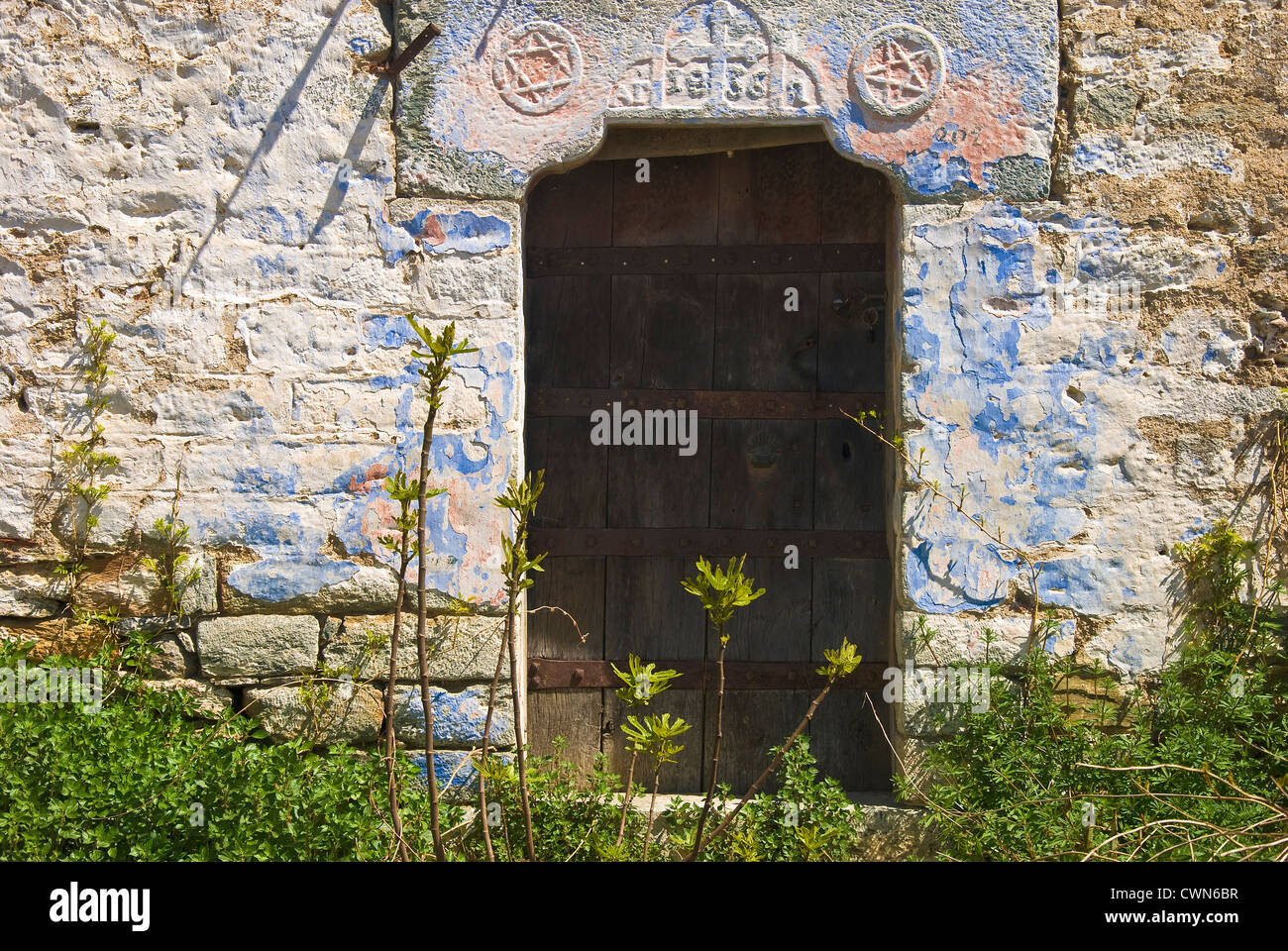 Facciata di un vecchio cottage in pietra con weathered porta di legno sulla penisola di Pelion, Tessaglia, Grecia Foto Stock