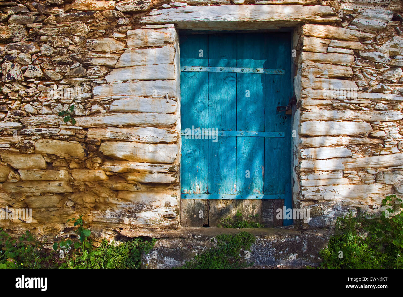 Facciata di un vecchio cottage in pietra con weathered porta di legno sulla penisola di Pelion, Tessaglia, Grecia Foto Stock