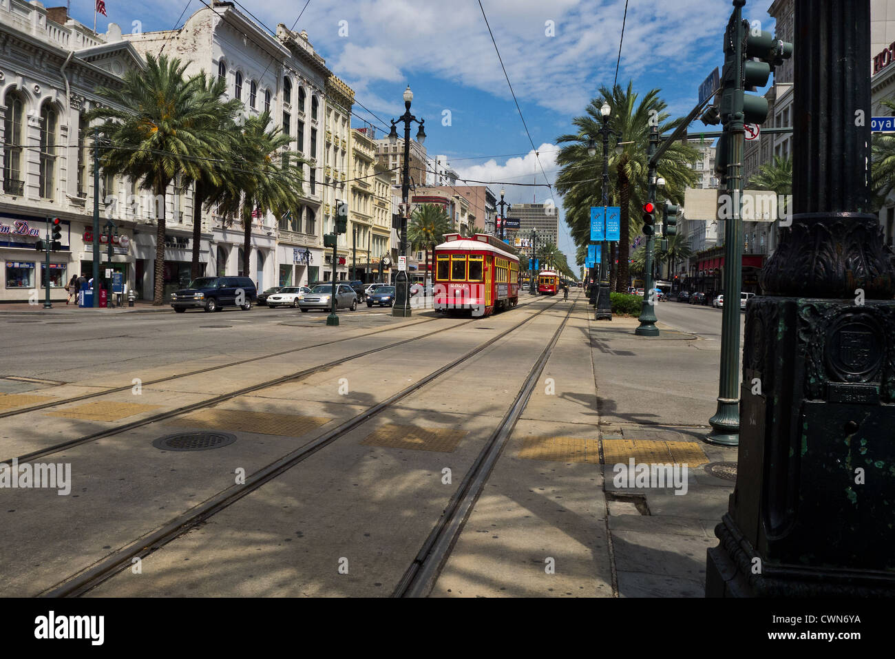 Una vista di Canal Street a New Orleans cercando uptown, mostrando tram, il traffico generale, palme, negozi e alberghi. Foto Stock