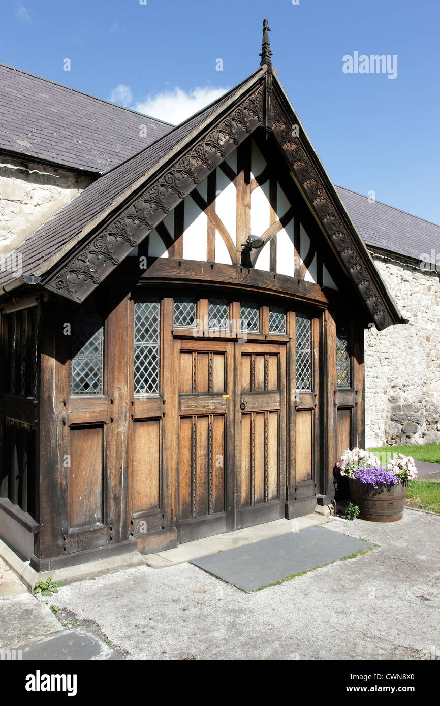 Gli ornati in legno intagliato portico all'ingresso di St Michael's Chiesa Parrocchiale, Abergele, il Galles del Nord. Foto Stock