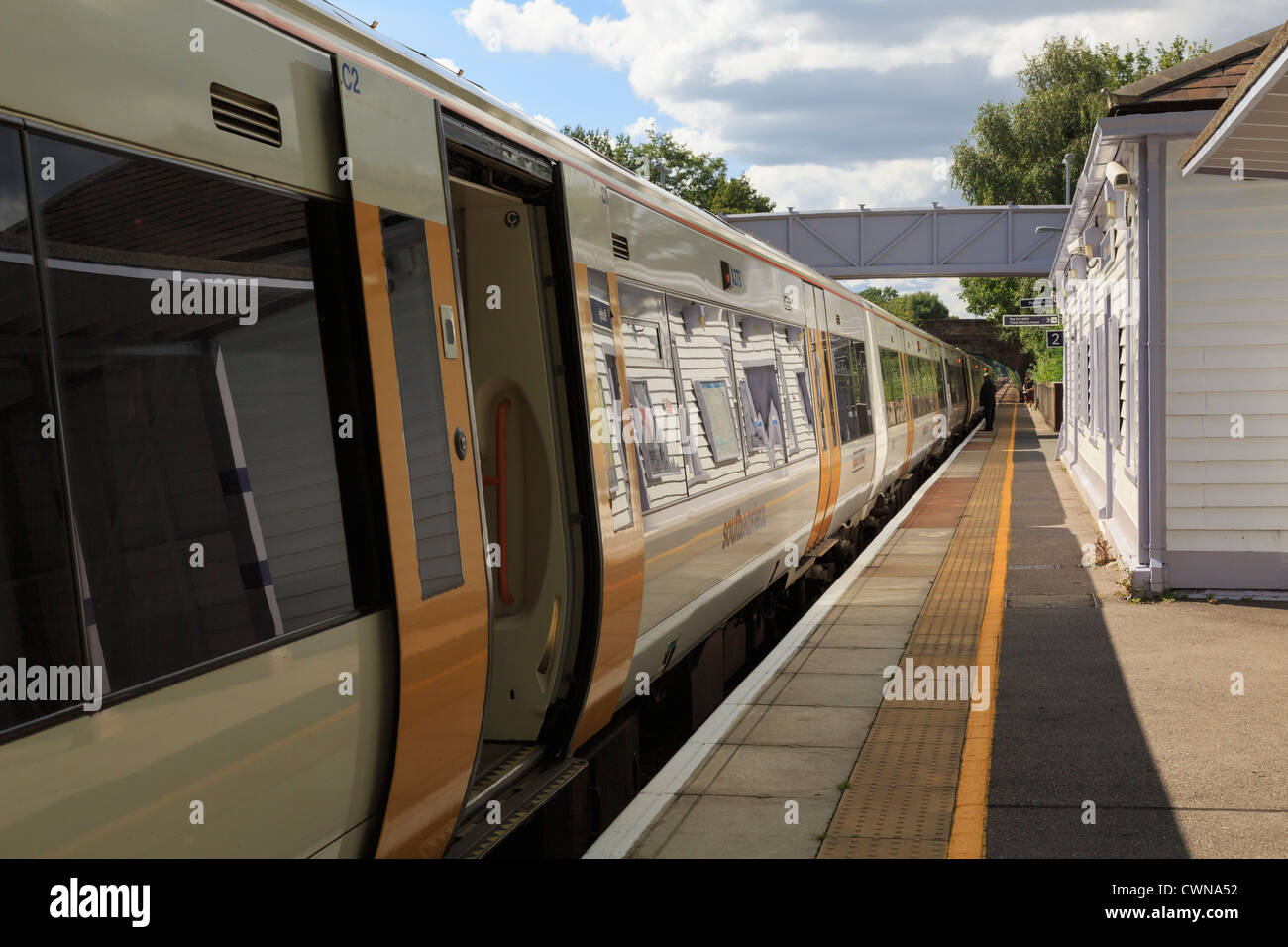 SouthEastern treno con porte aperte arrestato dalla piattaforma alla stazione ferroviaria su Londra a Ashford linea a Pluckley Kent England Regno Unito Foto Stock