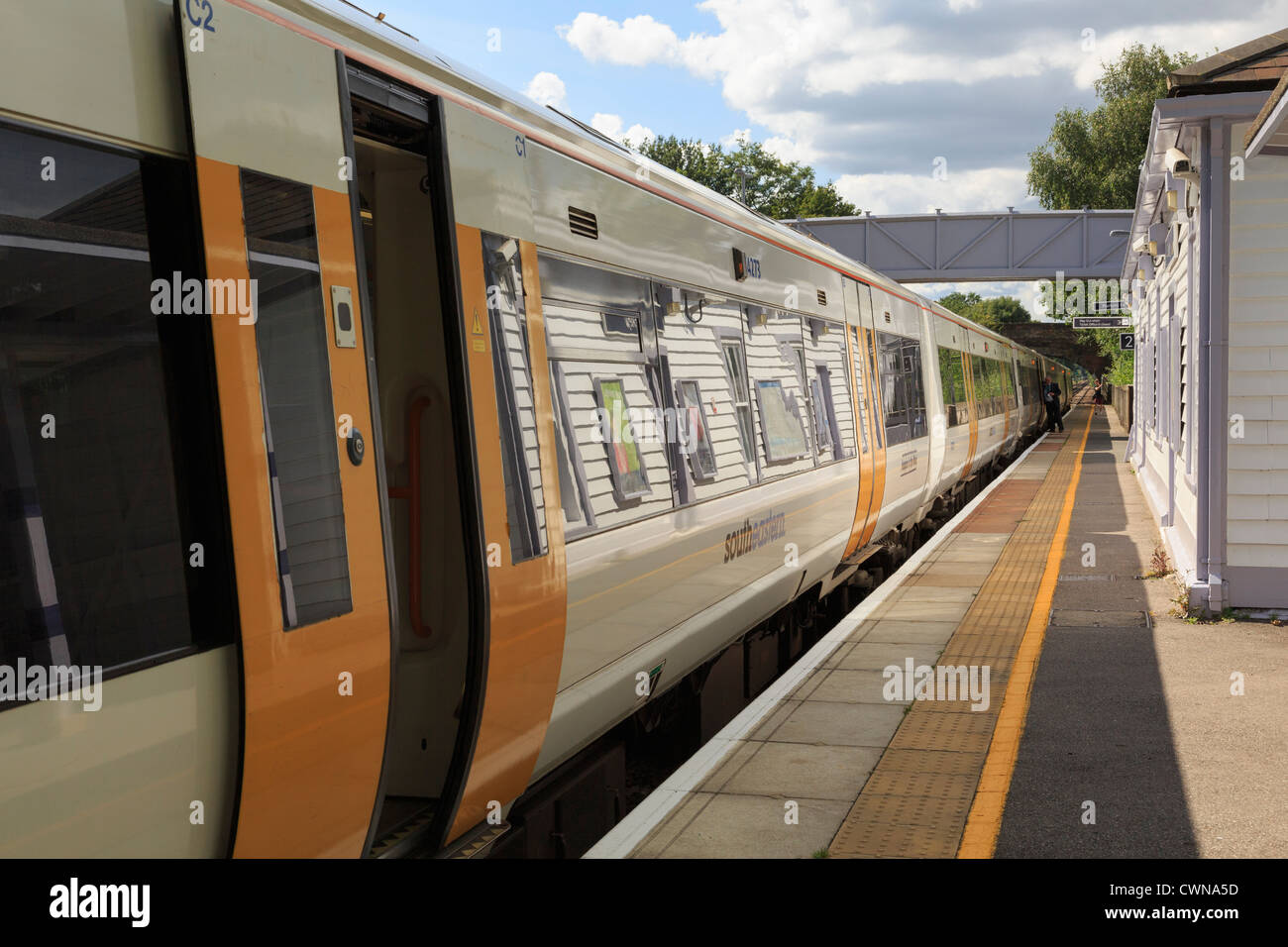 SouthEastern treno con porte aperte arrestato dalla piattaforma alla stazione ferroviaria su Londra a Ashford linea a Pluckley Kent England Regno Unito Foto Stock