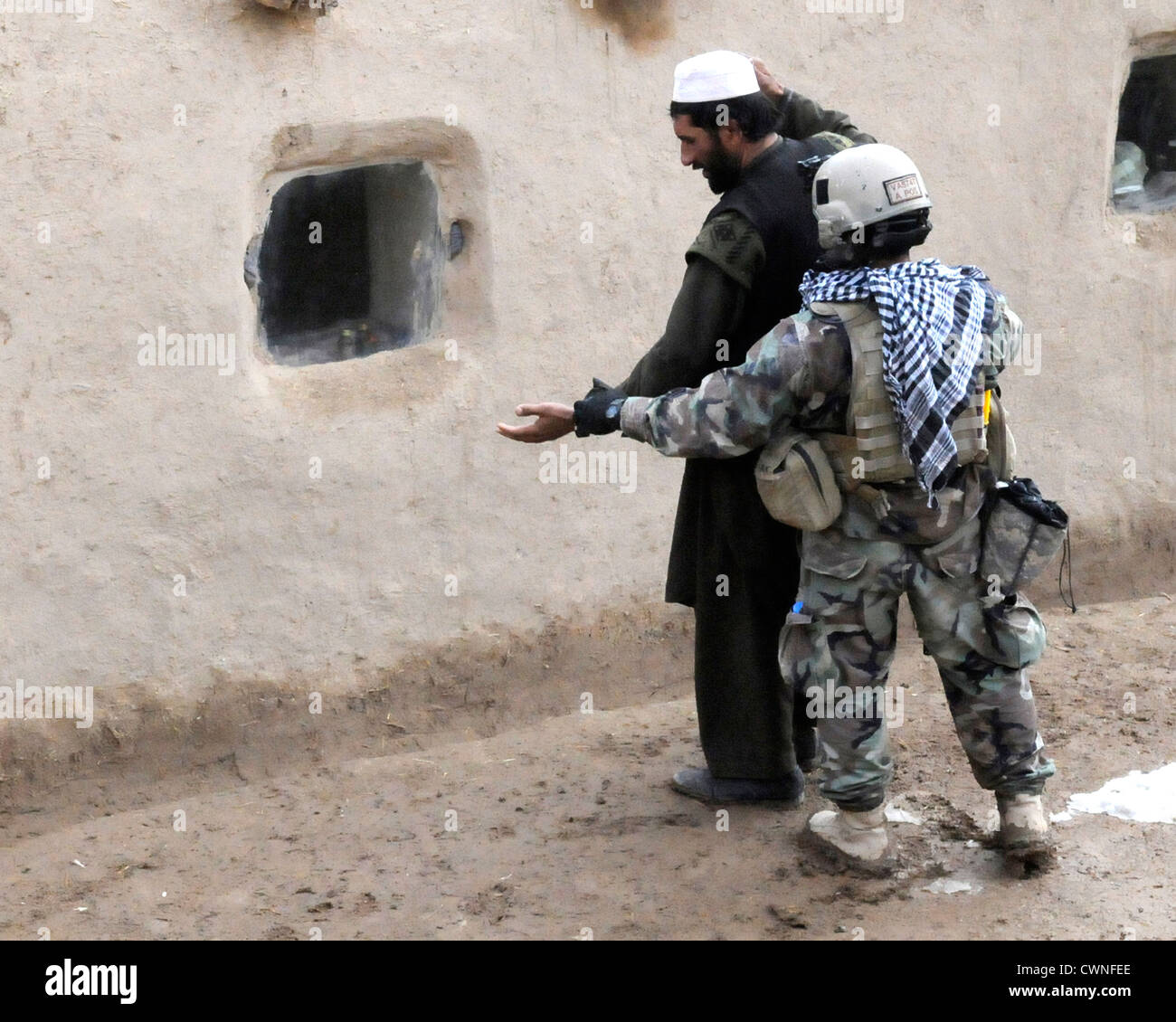 Una delle forze speciali soldato cerca un locale sospetti al di fuori di una bomba sospetta making facility Dicembre 10, 2009 in un remoto villaggio nel distretto di Arghandab, Afghanistan. Foto Stock